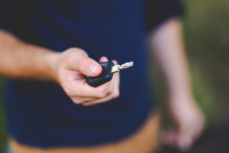 Hand holding out a car key