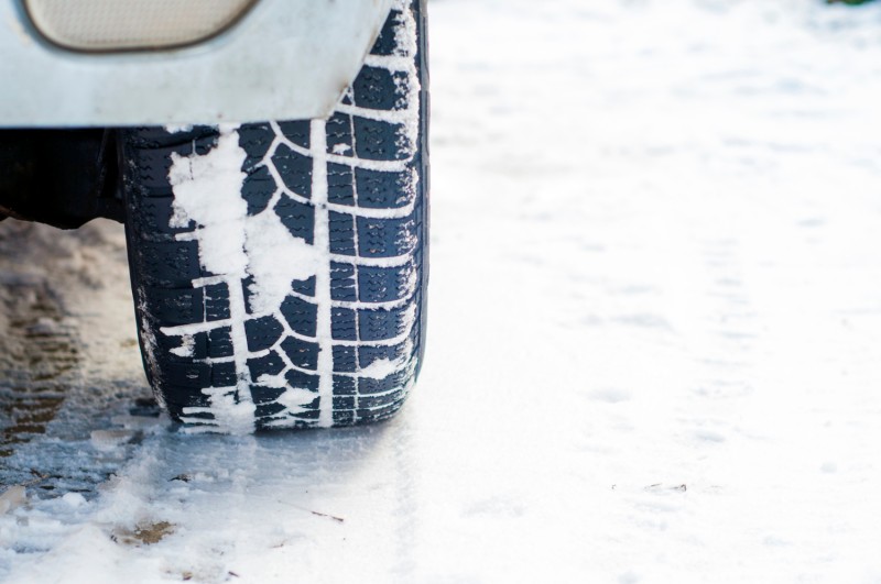 Car tyre on winter road covered with snow