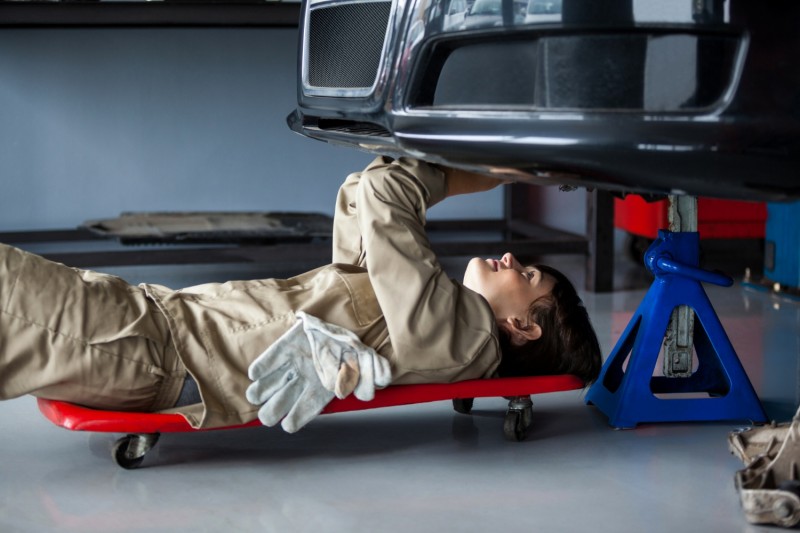 Female mechanic repairing a car