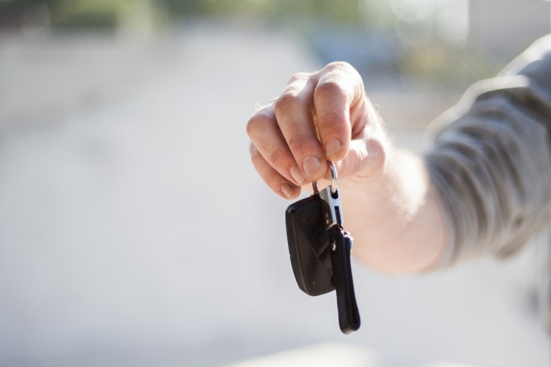 Car owner handing over keys at the end of a sale