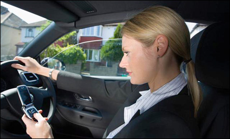 Woman texting on a phone whilst driving